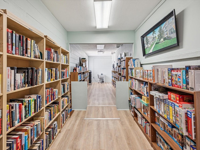 miscellaneous room with a textured ceiling and light wood-type flooring