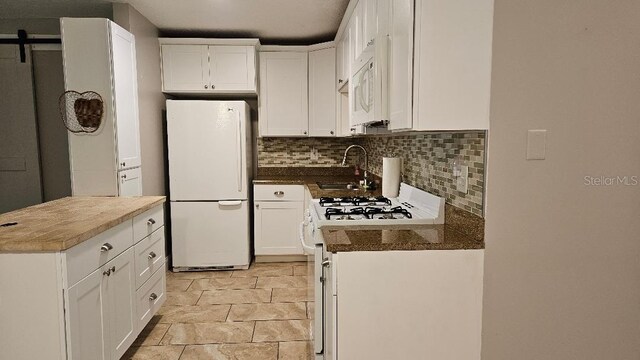 kitchen with light tile patterned flooring, sink, white appliances, tasteful backsplash, and white cabinetry