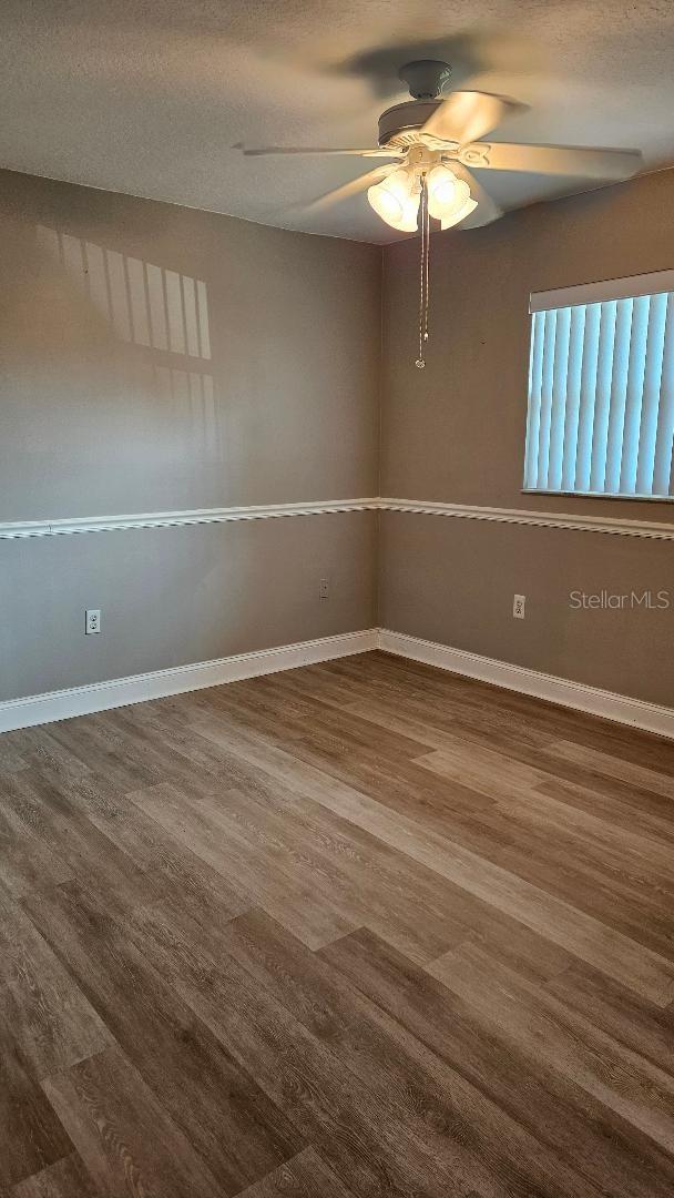 spare room with a textured ceiling, ceiling fan, and hardwood / wood-style flooring