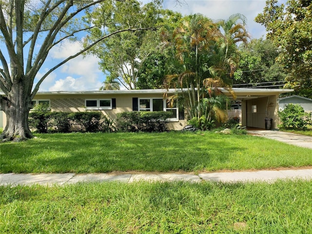 ranch-style home with a carport and a front lawn