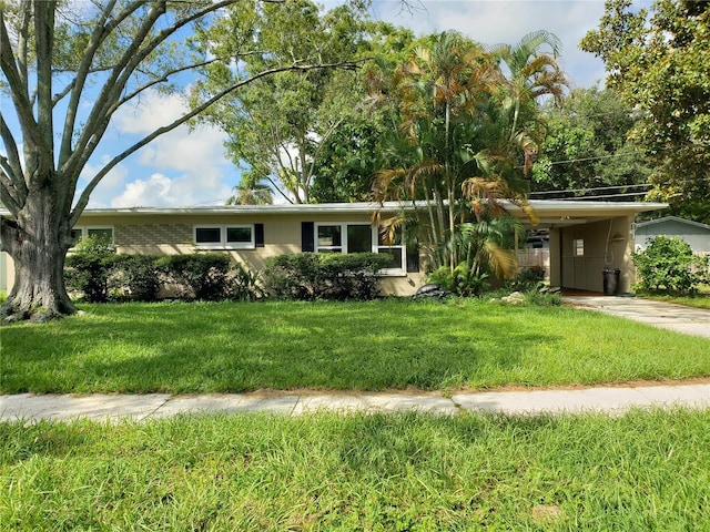 ranch-style home featuring a front lawn, a carport, and brick siding