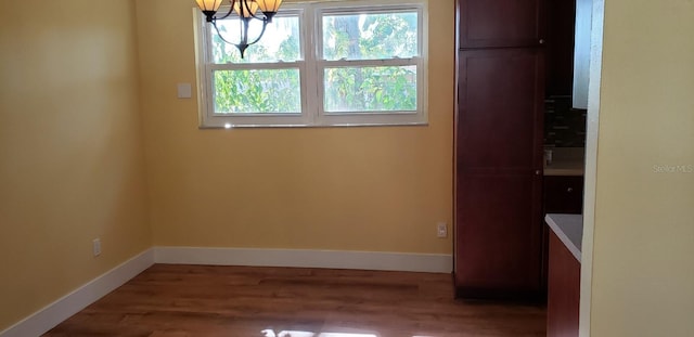 unfurnished dining area with hardwood / wood-style flooring and an inviting chandelier