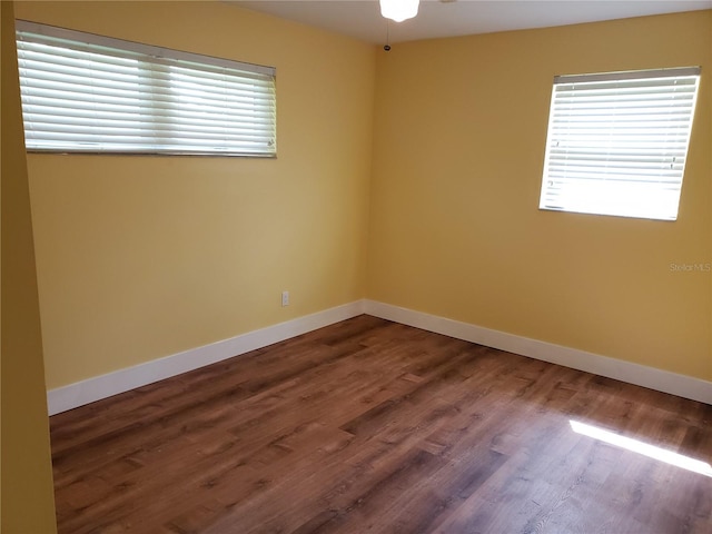 spare room featuring ceiling fan and dark wood-type flooring