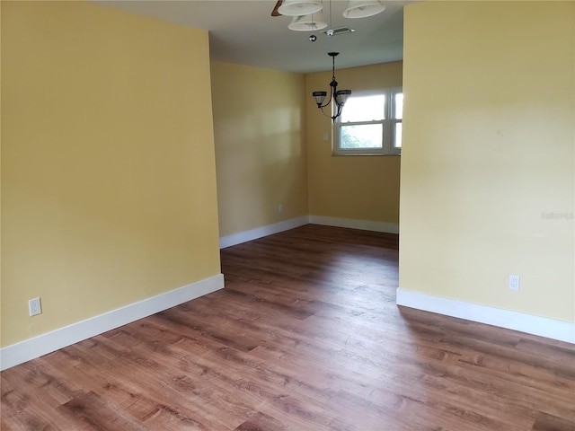 unfurnished dining area with hardwood / wood-style floors and a notable chandelier