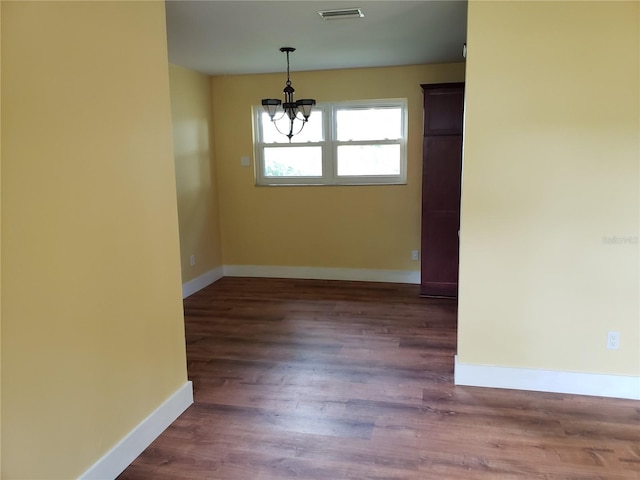 unfurnished dining area featuring dark hardwood / wood-style flooring and a chandelier