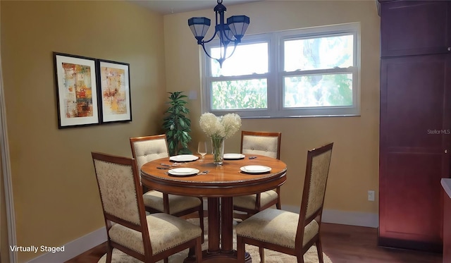 dining area with hardwood / wood-style floors and a chandelier