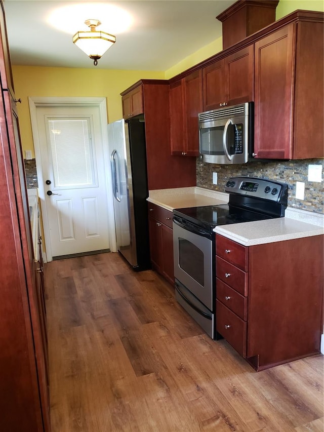 kitchen featuring tasteful backsplash, stainless steel appliances, and light hardwood / wood-style flooring