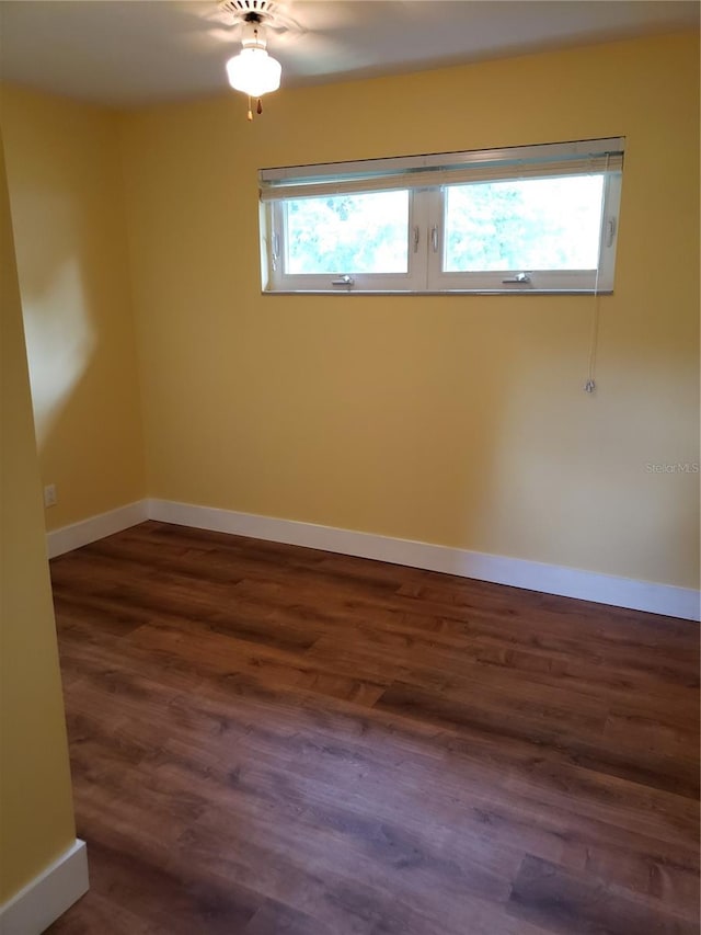 empty room with plenty of natural light and dark wood-type flooring