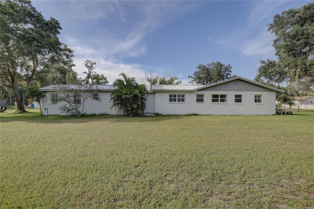 rear view of property featuring a yard