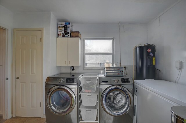 laundry room with water heater, light tile patterned floors, washer and clothes dryer, and cabinets