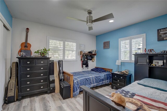 bedroom featuring multiple windows, ceiling fan, a closet, and light hardwood / wood-style flooring