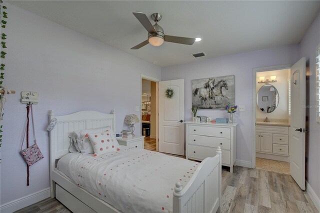 bedroom with ceiling fan, sink, light hardwood / wood-style floors, and ensuite bathroom