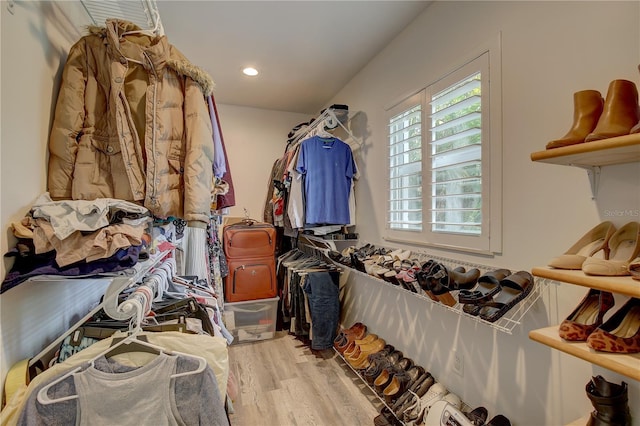 walk in closet with light hardwood / wood-style floors