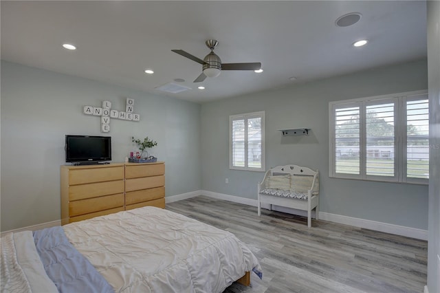 bedroom featuring ceiling fan, light hardwood / wood-style flooring, and multiple windows