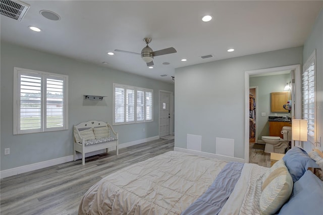 bedroom with light wood-type flooring, ceiling fan, and ensuite bathroom