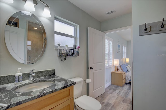 bathroom with hardwood / wood-style floors, vanity, and toilet