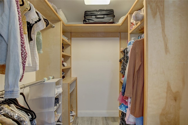 walk in closet with light hardwood / wood-style floors