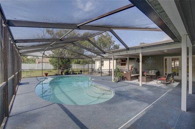 view of swimming pool featuring a lanai, an outdoor living space, and a patio area