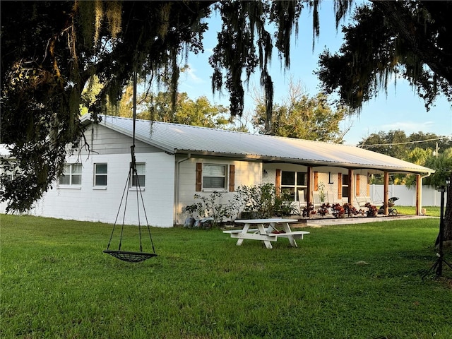 rear view of house featuring a yard