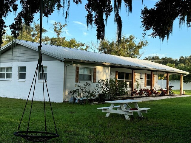 7809 Alafia Dr, Riverview, FL 33578 - view of front of house with a front yard, metal roof, and covered porch