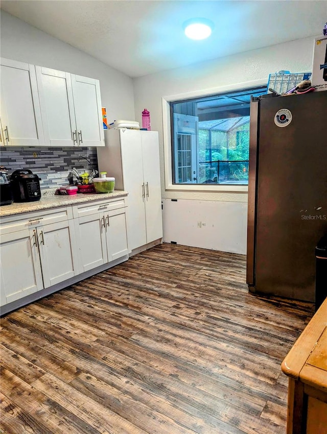 kitchen with white cabinetry, stainless steel fridge, dark hardwood / wood-style flooring, and tasteful backsplash