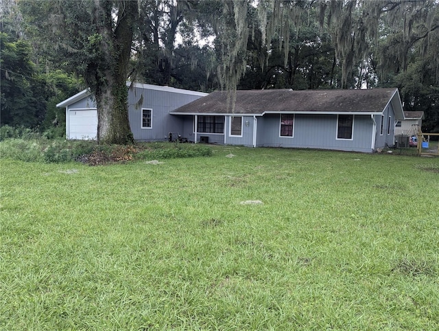 ranch-style house featuring a garage and a front lawn