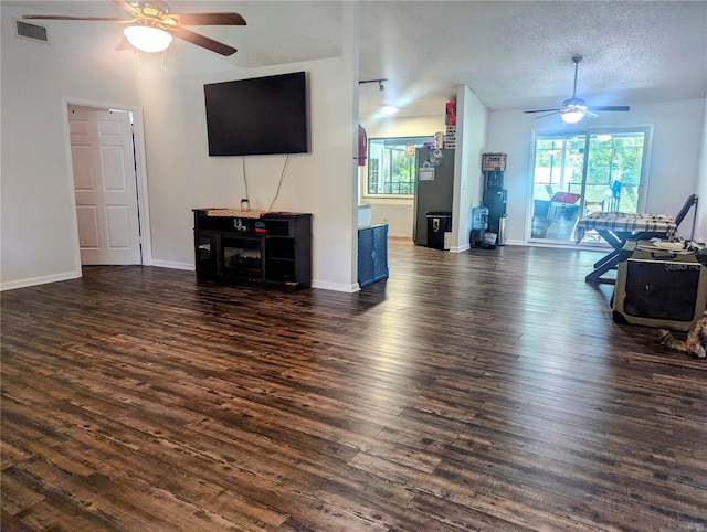 living room featuring ceiling fan, dark hardwood / wood-style flooring, and a textured ceiling