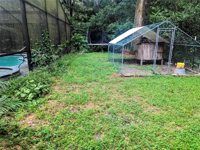 view of yard with an outbuilding and a trampoline