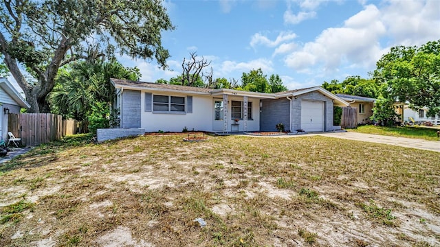 single story home featuring concrete driveway, an attached garage, fence, and a front yard