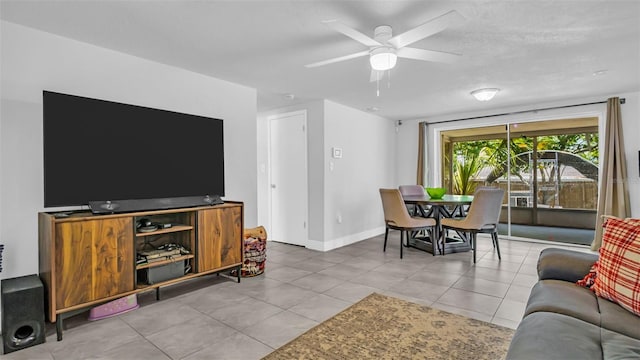 living area featuring a ceiling fan, baseboards, and light tile patterned floors