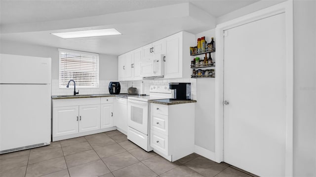 kitchen featuring light tile patterned flooring, white appliances, a sink, white cabinetry, and backsplash