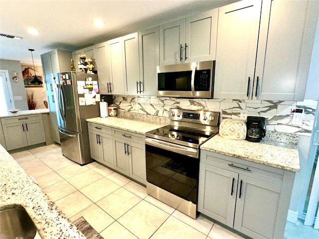 kitchen with backsplash, stainless steel appliances, pendant lighting, light tile patterned floors, and gray cabinets