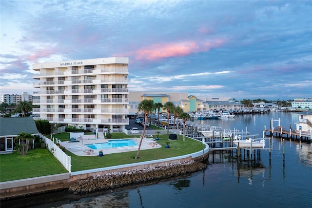 exterior space with a yard, a water view, and a community pool