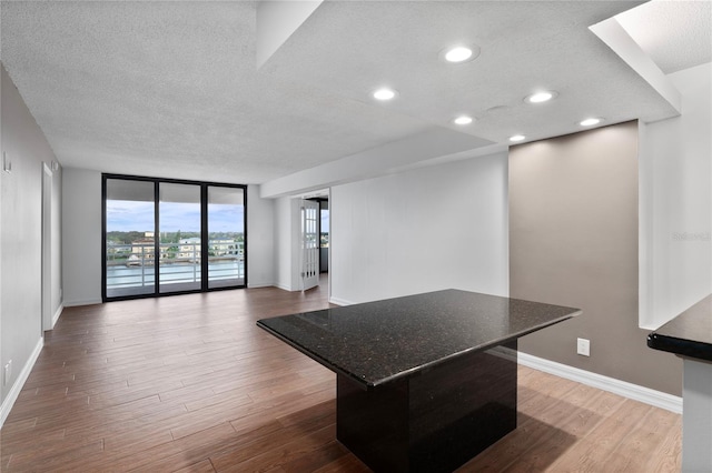 interior space with wood-type flooring, a textured ceiling, and floor to ceiling windows