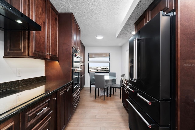 kitchen with light hardwood / wood-style floors, a textured ceiling, range hood, high end black fridge, and dark stone countertops