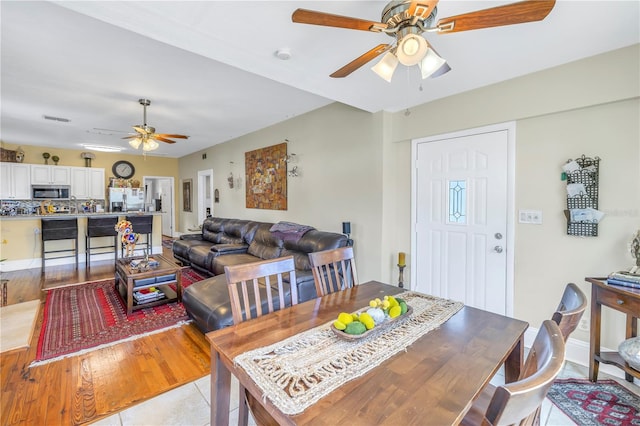 dining space with ceiling fan and light hardwood / wood-style flooring