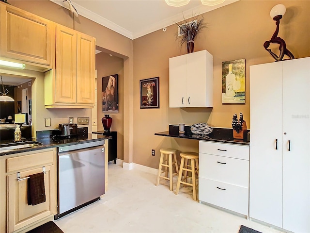 kitchen featuring dark countertops, a sink, baseboards, and stainless steel dishwasher