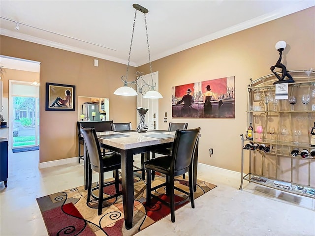 dining area with finished concrete floors, baseboards, and crown molding