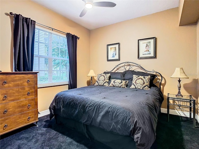 bedroom with baseboards, dark carpet, and a ceiling fan