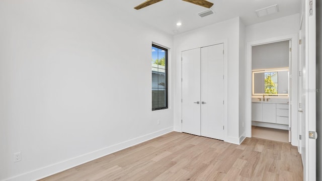 unfurnished bedroom with light wood-style floors, visible vents, baseboards, and multiple windows