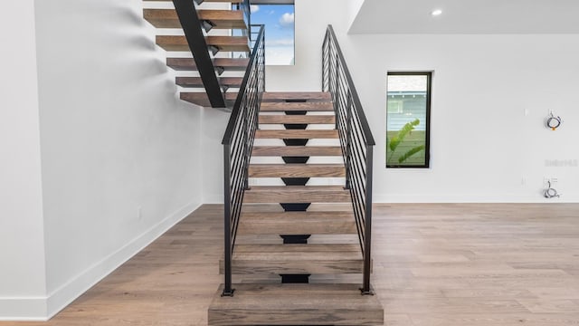 staircase with recessed lighting, wood finished floors, and baseboards