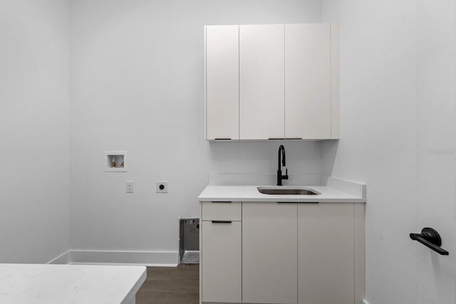 laundry room with cabinets, sink, hookup for a washing machine, hookup for an electric dryer, and dark hardwood / wood-style flooring