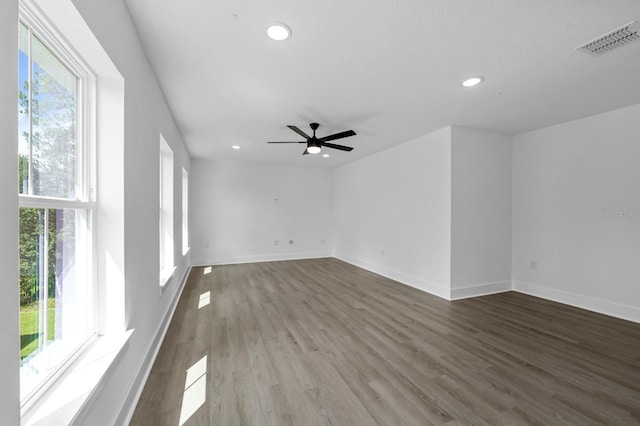 spare room with a wealth of natural light, ceiling fan, and hardwood / wood-style flooring