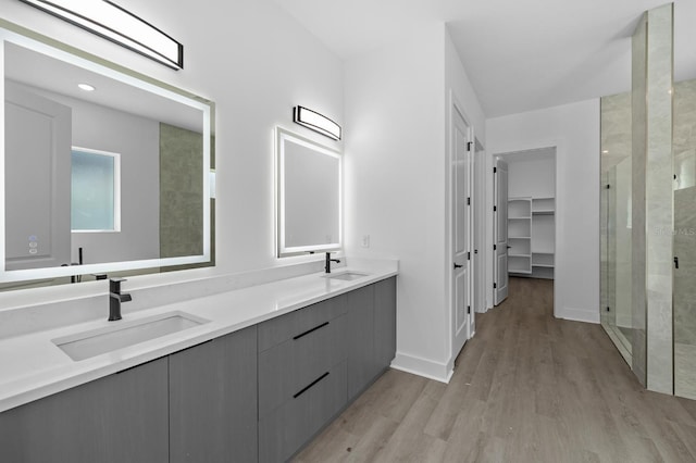 bathroom featuring wood-type flooring, vanity, and walk in shower