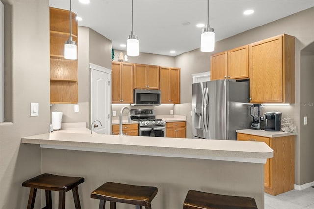 kitchen featuring a breakfast bar area, hanging light fixtures, light tile patterned floors, kitchen peninsula, and stainless steel appliances