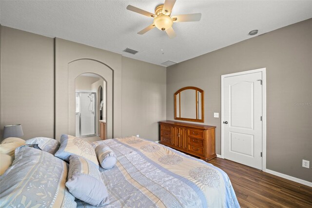 bedroom with ceiling fan, ensuite bathroom, dark hardwood / wood-style floors, and a textured ceiling