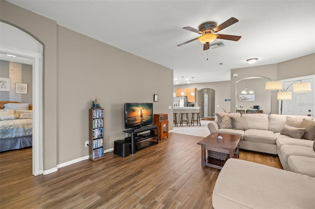 living room featuring dark wood-type flooring and ceiling fan