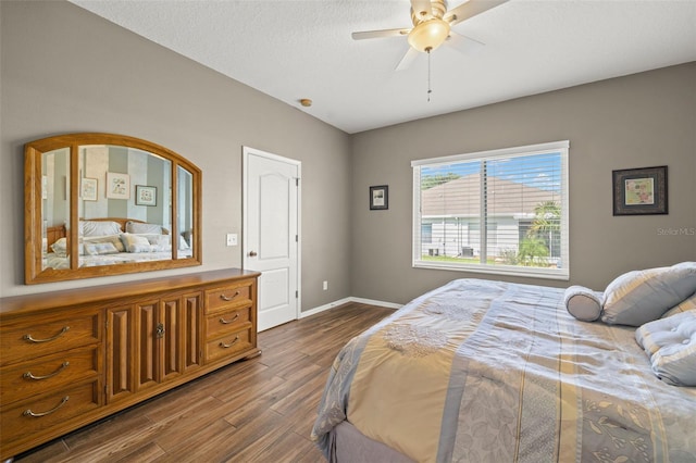 bedroom featuring hardwood / wood-style flooring, a textured ceiling, and ceiling fan