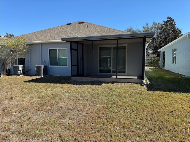 rear view of house with cooling unit and a lawn