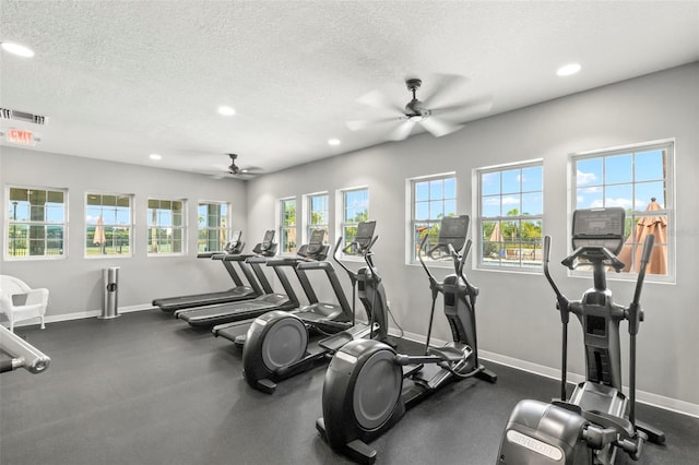 workout area featuring ceiling fan and a textured ceiling